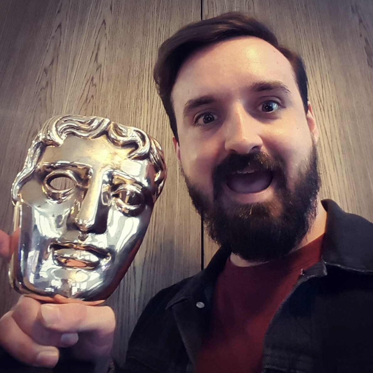 Sam Paul Toms holding a bafta for best vfx for the tv show the crown, awarded to vfx company One of Us